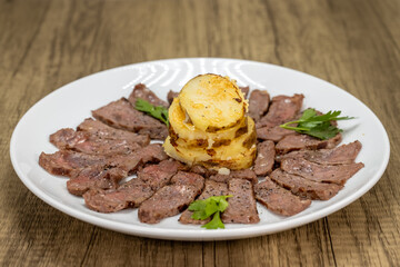 Thin cut New York steak cooked to perfection served with a stack of mashed potatoes