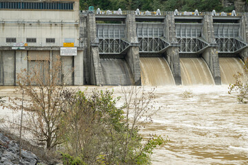 Fort Patrick Henry Dam, spilling, muddy flood waters from four spillways. Located in Sullivan County in Kingsport, Tennessee on the South Fork Holston River.