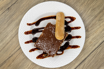 Overhead view of no Italian meal is complete without tasting the tiramisu layered cake with chocolate garnishment