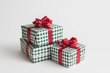 Fototapeta premium Festive Christmas gift boxes with checkered wrapping and red ribbons