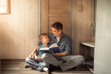 happy father and son reading book at home. children education, development. father and child...