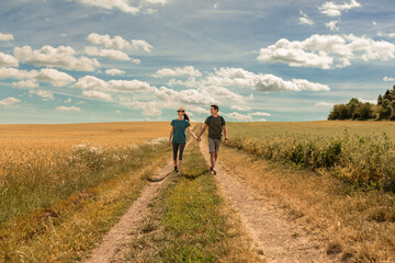 Happy carefree couple walking hiking through the beautiful countryside on a sunny day 