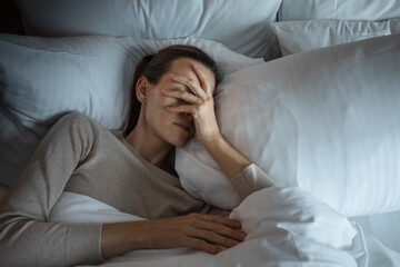 Young woman waking up in the morning feeling tired suffering from insomnia bad sleep
