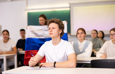 Obraz premium A young student is carefully recording a lecture by a school teacher