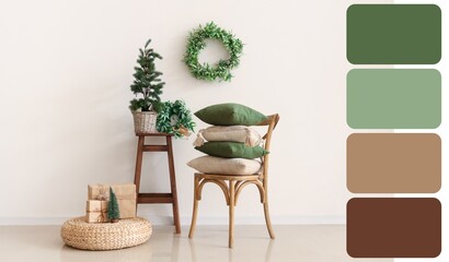 Cozy home interior with decorative pillows on chair, mini Christmas tree and mistletoe wreath. Different color pattern
