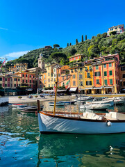 Sunny day in Portofino, Liguria, Italy. Colorful houses and boats in Portofino's harbor. Luxury destination.
