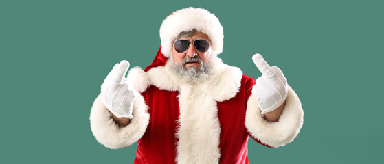 Bad Santa Claus showing middle fingers on green background