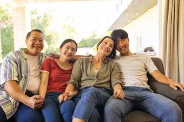 Smiling small family sitting on couch, enjoying quality time together