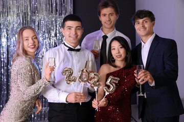 Group of young people with champagne and figure 2024 at Christmas party