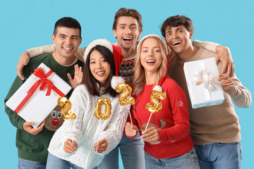 Group of young people with figure 2024 and Christmas presents on blue background