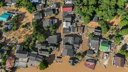 Fototapeta premium Aerial view of Karen Ruammit Elephant Camp village in Chiang Rai province of Thailand flooded by river after typhoon Yagi swept across Thailand.