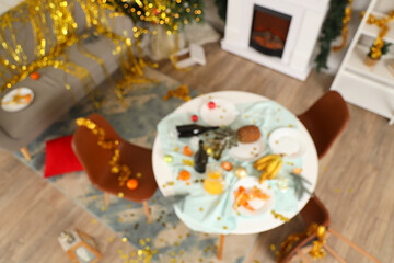 Blurred view of messy living room after New Year party, top view
