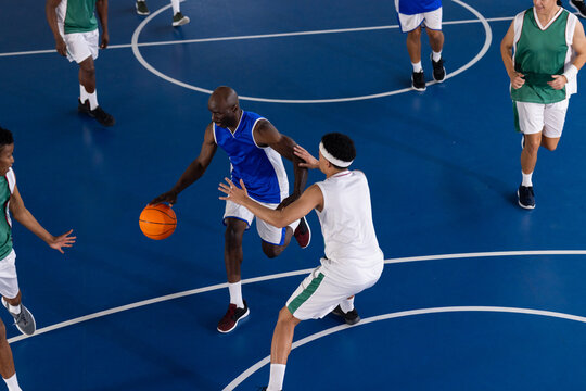 Playing basketball, athletes in action on court during competitive game