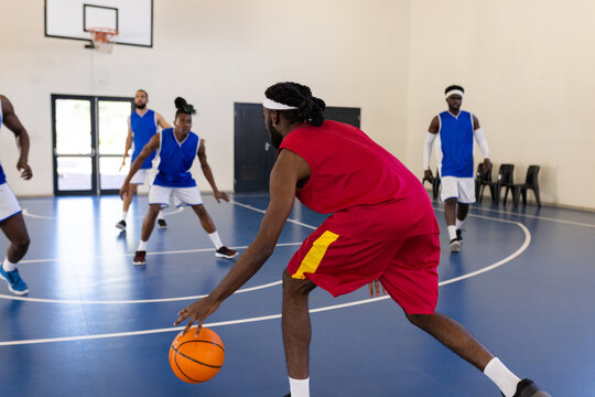 Playing basketball, athletes in action on indoor court during game