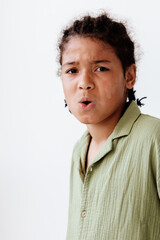 Excited young boy with mouth open in amazement against a clean white background