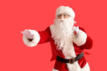 Santa Claus with bag of gifts on red background