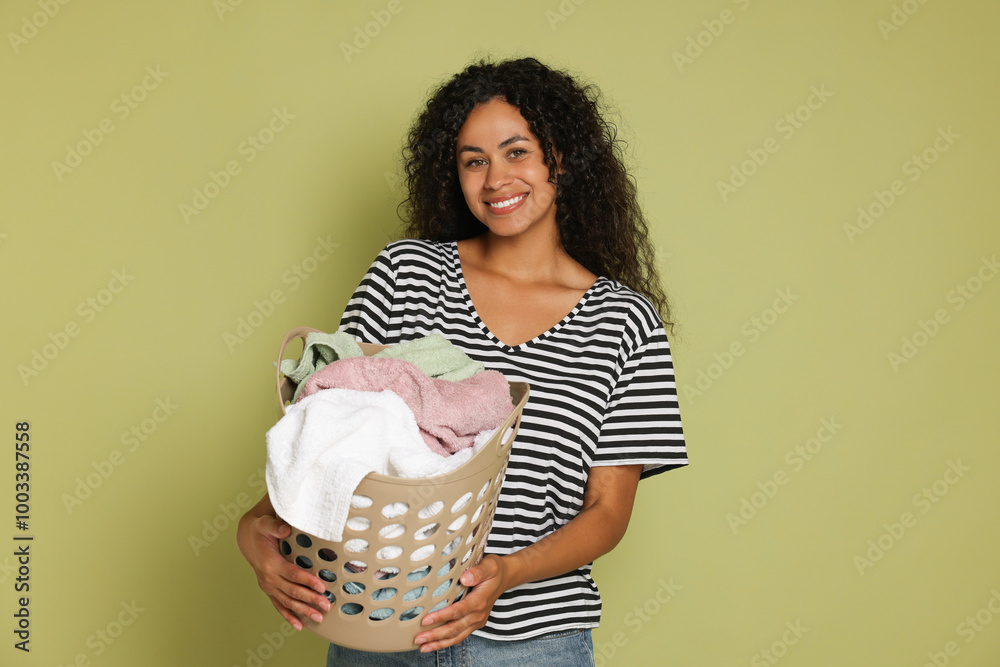 Sticker Happy woman with basket full of laundry on olive background