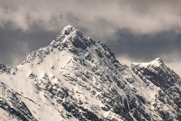 Stunning mountain peaks seen from the top of the Banff Gondola during spring time with snow capped mountains surrounding the alpine peak area. 