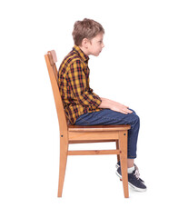 Boy with incorrect posture sitting on chair against white background