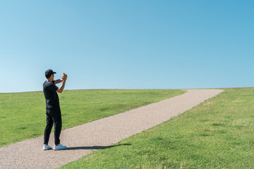 青空の下の公園でストレッチするスポーツウェア姿の中年男性