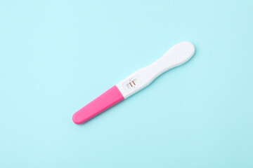One pregnancy test on light blue background, above view