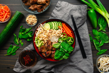 Bun Thit Nuong Vietnamese Grilled Pork with Nuoc Cham: Chunks of pork over vermicelli noodles with fresh herbs, peanuts, cucumber, and pickled carrots