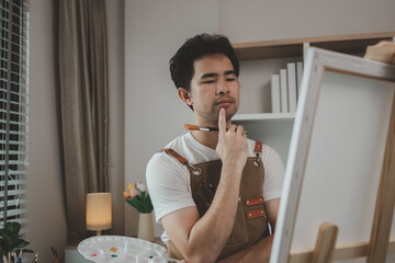 a painter is in his painting studio, a rising male artist is focusing on creating his best...