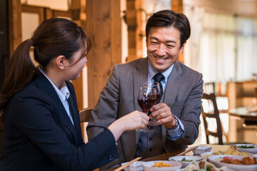 居酒屋で忘年会・新年会・飲み会・宴会をする仕事仲間・同僚・上司部下の男女
