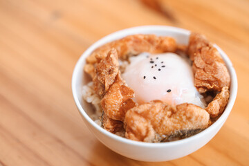 Asian rice bowl with poached egg, fried salmon with skin, and black sesame seeds.