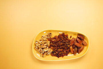 A vibrant assortment of assorted nuts and dried fruits beautifully displayed on a yellow background