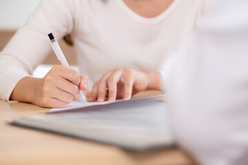 Closeup hand writing on paper for signature about insurance or agreement medical in modern medical...