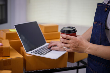 close-up of a man's hands working meticulously with a cardboard box on wooden desk, representing an...