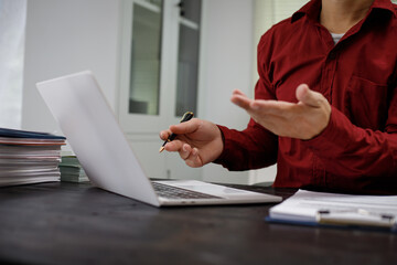 close-up of a lawyer’s hands working at a desk, reviewing legal documents and contracts, with a wooden gavel nearby, symbolizing law, legislation, and the potential complexities of bribery cases.