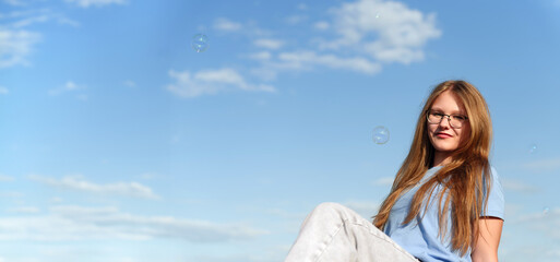 Silhouetted by the vibrant azure backdrop, a female subject's expression is heightened by the...