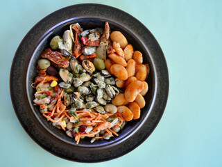 Smoked mussels with Greek gigantes beans, antipasto and bean salad on a plate.