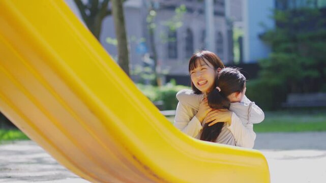 滑り台で遊ぶ子供と見守る保育士の女性	
