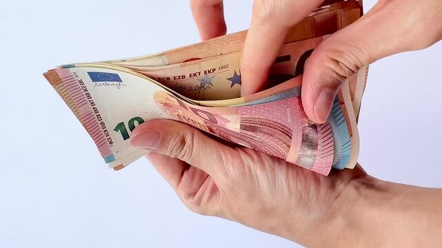 4K footage of hands and fingers counting Euro Money from the nominal of 50 Euro to 20 and 10 Euro. Hands counting Euro banknotes isolated on white background.
