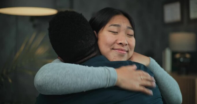 Happy multiethnic couple sit on chairs, talk, hug and find compromise after quarrel on couples therapy. Reconciliation of tender young family on counseling session with psychologist or psychotherapist