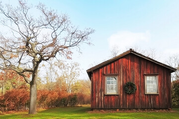 Rustic wooden cabin in serene autumn countryside with wreath AI generated