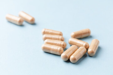 Ashwagandha (Withania somnifera) capsules. Concept for a healthy dietary supplementation. Bright paper background. Close up. Copy space.	