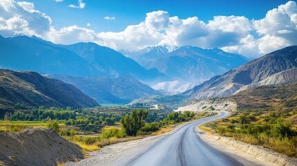 Fototapeta premium Scenic Mountain Road with Lush Greenery and Blue Sky