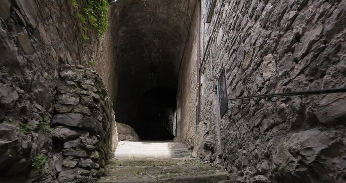 Narrow pedestrian tunnel leading to the Church of Saint George, Varenna, Italy. Lake Como. City attraction. Holidays in Italian Alps