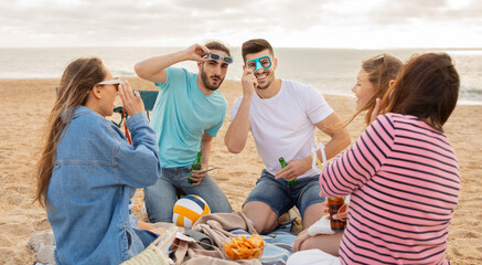 A group of friends gathers on the beach, sharing snacks and drinks while wearing sunglasses. Laughter fills the air as they relax on a blanket, enjoying a perfect evening by the sea.