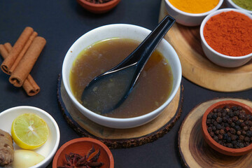 mutton soup, chicken soup, vegetable soup along with onion or creamy onion raita, lemon, Star anise, cinnamon, pepper, clove, chutney, chicken gravy and spices on white bowl