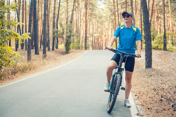 Fototapeta premium woman cyclist rides in the forest on a bike.