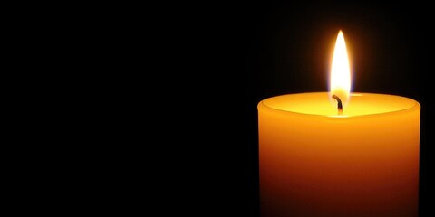 A flickering candle illuminates the darkness, casting a warm glow in a serene setting, creating a peaceful ambiance perfect for quiet reflection