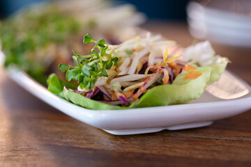 A plate of vegetable lettuce wraps on a wood table