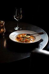 A dish of ravioli covered in sauce vertical