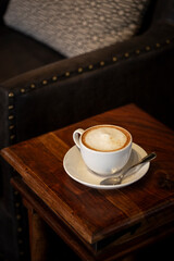 Large cafe latte with foamed milk sitting on side table
