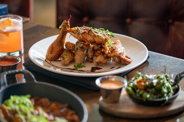 A chicken dish served with sides and a drink on a table